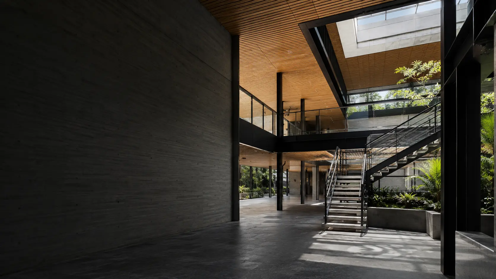 Átrio institucional contemporâneo com concreto aparente, aço e madeira